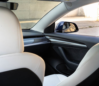 Tesla Model 3 with white interior seating and carbon door panels